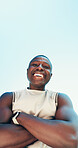 Below, fitness and portrait of black man on blue sky for running, exercise and workout outdoor. Happy, crossed arms and person with smile for marathon training, sports and challenge for endurance