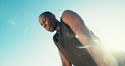 Buy stock photo Black man, fitness or break with blue sky for rest, recovery or training below in nature. Male person, African runner or tired athlete breathing in fatigue for workout exercise or physical activity