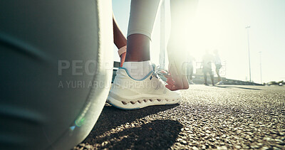 Buy stock photo Person, runner and tying laces on asphalt for workout preparation, exercise or physical activity. Foot, sneakers or getting ready with tie or shoes on city street for run, fitness or training in town