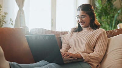 Buy stock photo Woman, laptop and relax on sofa with smile, typing and search for movie in lounge at apartment. Girl, happy and chill on couch with computer, streaming or post on social media in living room at house