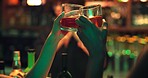 Hands, toast and celebration with drinks at nightclub with whiskey, party or social event at bar. Friends, girl and people at reunion with glass, alcohol or beverage for new years eve at restaurant