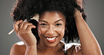 Makeup, brush and portrait of African happy woman in studio for foundation, cosmetics and beauty products. Smile, salon and person with tools for skincare, makeover and aesthetic on gray background