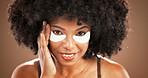 Facial, eye mask and portrait of black woman on brown background for skincare, dark circles and wellness. Dermatology, collagen and face of person for beauty, anti aging and cosmetics for health