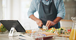 Food, tablet and man cutting vegetables in home for cooking healthy dinner, meal or supper for diet. Technology, groceries and chef chop fresh ingredients for wellness, nutrition or recipe in kitchen