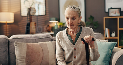 Buy stock photo Sadness, thinking and senior woman with cane, depression or lonely with loss in living room or home. Serious, reflection and old person with walking stick, remember and grief for death in house