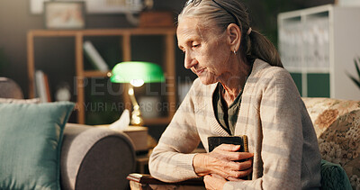 Buy stock photo Sad, old woman and thinking with picture frame in home for mourning, grief and lonely in retirement. Senior widow, person with depression and hug photo on sofa for nostalgia, memory or broken heart