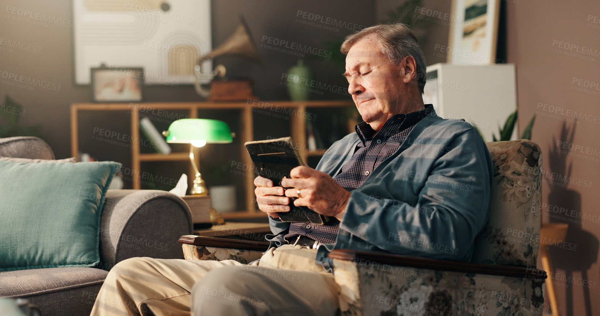 Buy stock photo Elderly, sad man and photo frame with memory for grief or loss in mourning on chair at home. Senior, male person or thinking with picture, depression or nostalgia for missing piece or lonely house