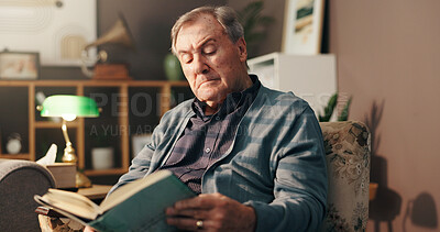 Buy stock photo Senior man, reading and book on sofa with poetry, literature and information in lounge at apartment. Elderly person, novel and knowledge on living room couch, language and storytelling in retirement
