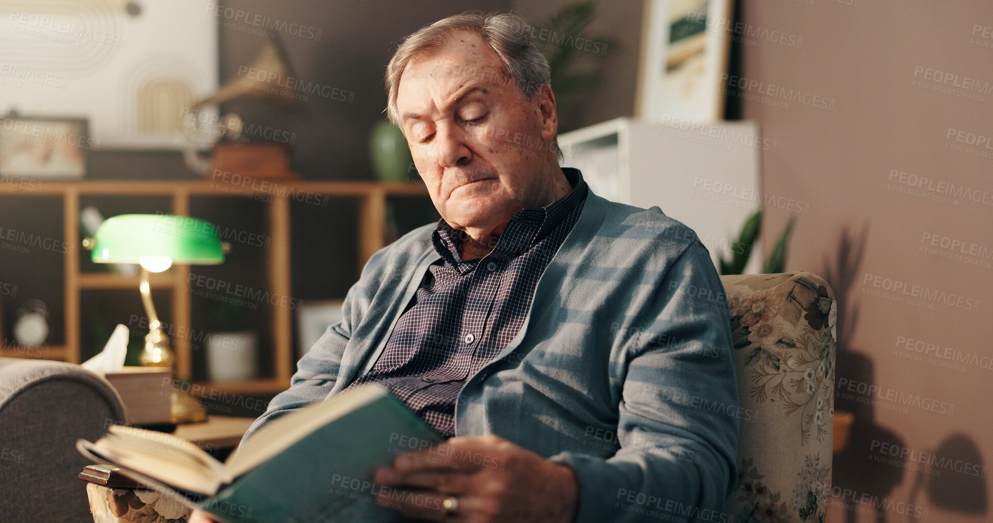 Buy stock photo Senior man, reading and book on sofa with poetry, literature and information in lounge at apartment. Elderly person, novel and knowledge on living room couch, language and storytelling in retirement
