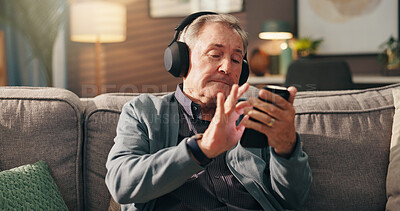 Buy stock photo Senior man, phone and listening to music with headphones on sofa for online streaming at home. Elderly, male person or user with mobile smartphone for podcast, radio news or entertainment at house