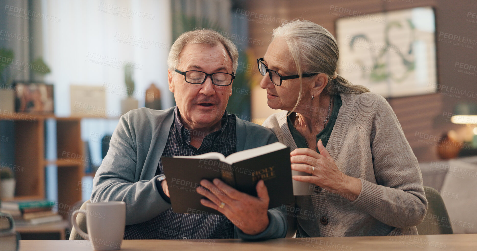 Buy stock photo Senior couple, bible and reading in home for faith, study or coffee with spiritual scripture in lounge. Old man, woman and book for learning with Christianity, religion or tea in house for retirement