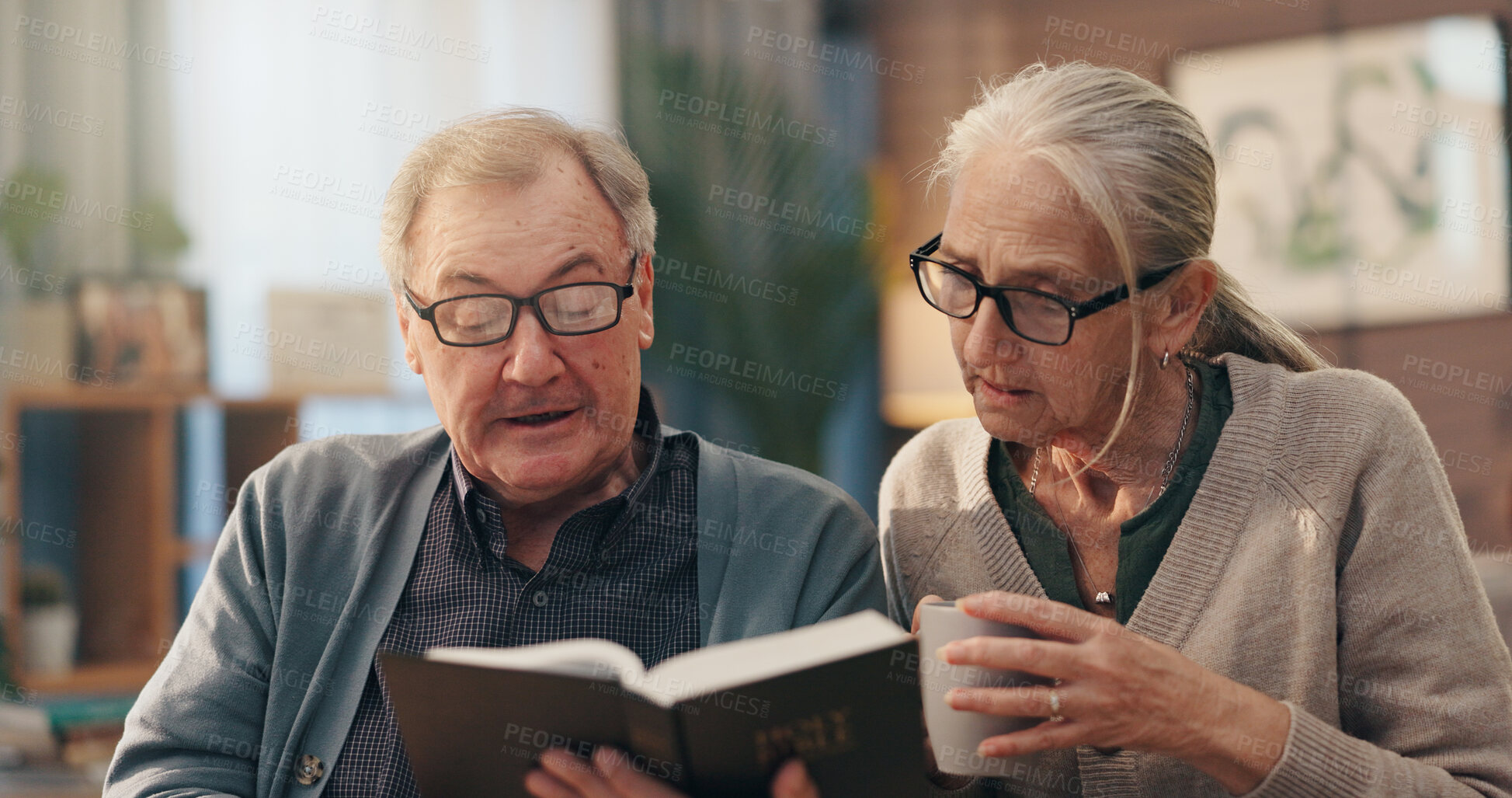 Buy stock photo Senior couple, bible and faith in home for reading, study and tea cup with spiritual scripture in lounge. Old man, woman and book for learning with Christianity, religion and coffee in retirement