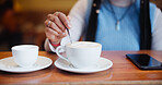 Hands, cafe and customer stirring coffee on table for beverage, espresso and drink preparation. Cup, latte and woman with spoon for mixing morning cappuccino with fresh cream in restaurant to relax