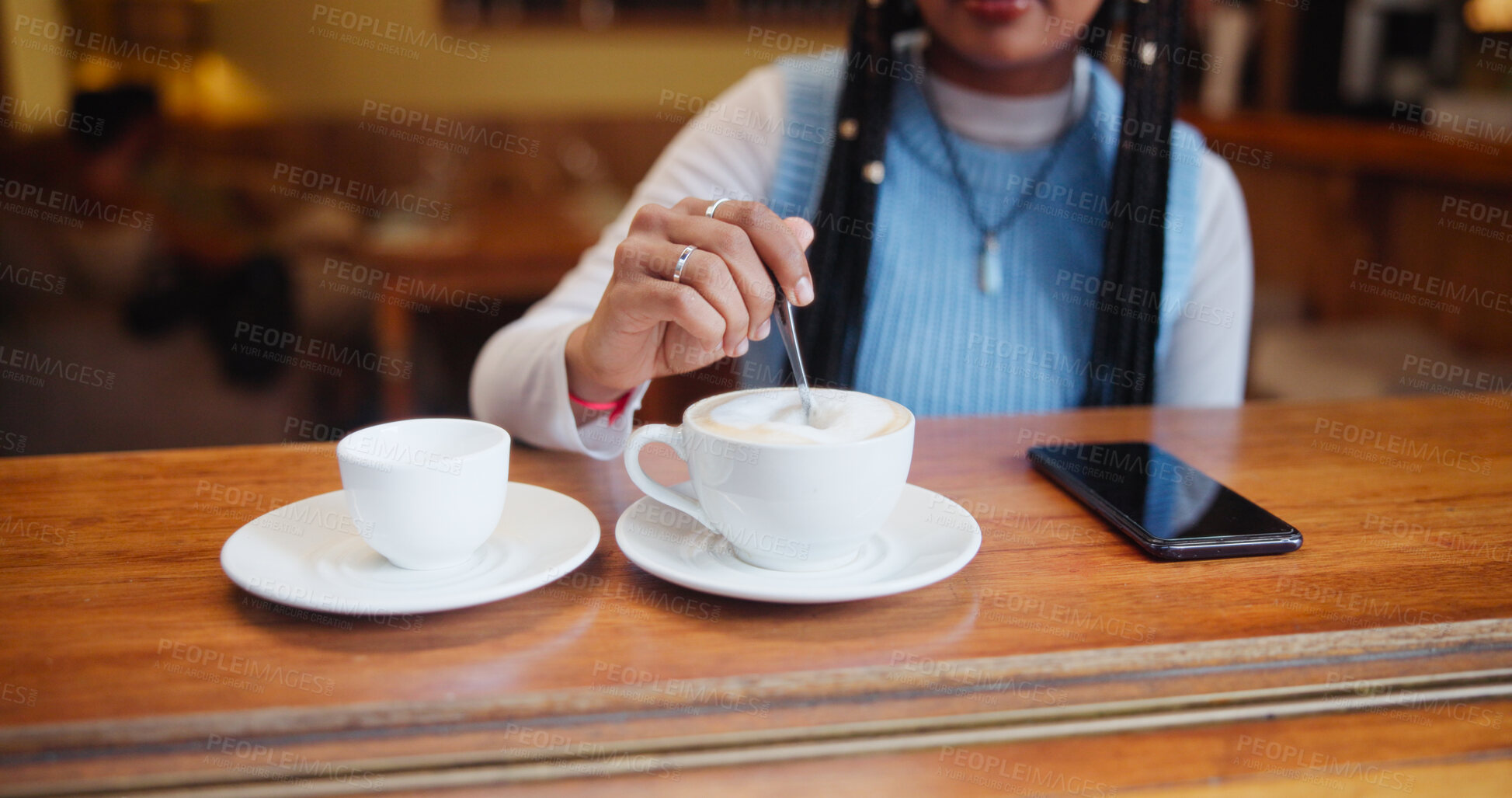 Buy stock photo Hands, drink and customer stir coffee on table for beverage, espresso and preparation. Cup, latte and woman with spoon for mixing morning cappuccino with fresh cream or foam in restaurant to relax