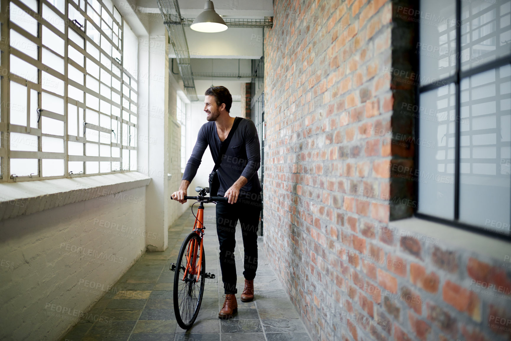 Buy stock photo Man, bicycle and smile in hallway on travel by window, thinking or ready for ride at office building. Person, happy and bike in corridor for sustainability with eco friendly transportation on commute