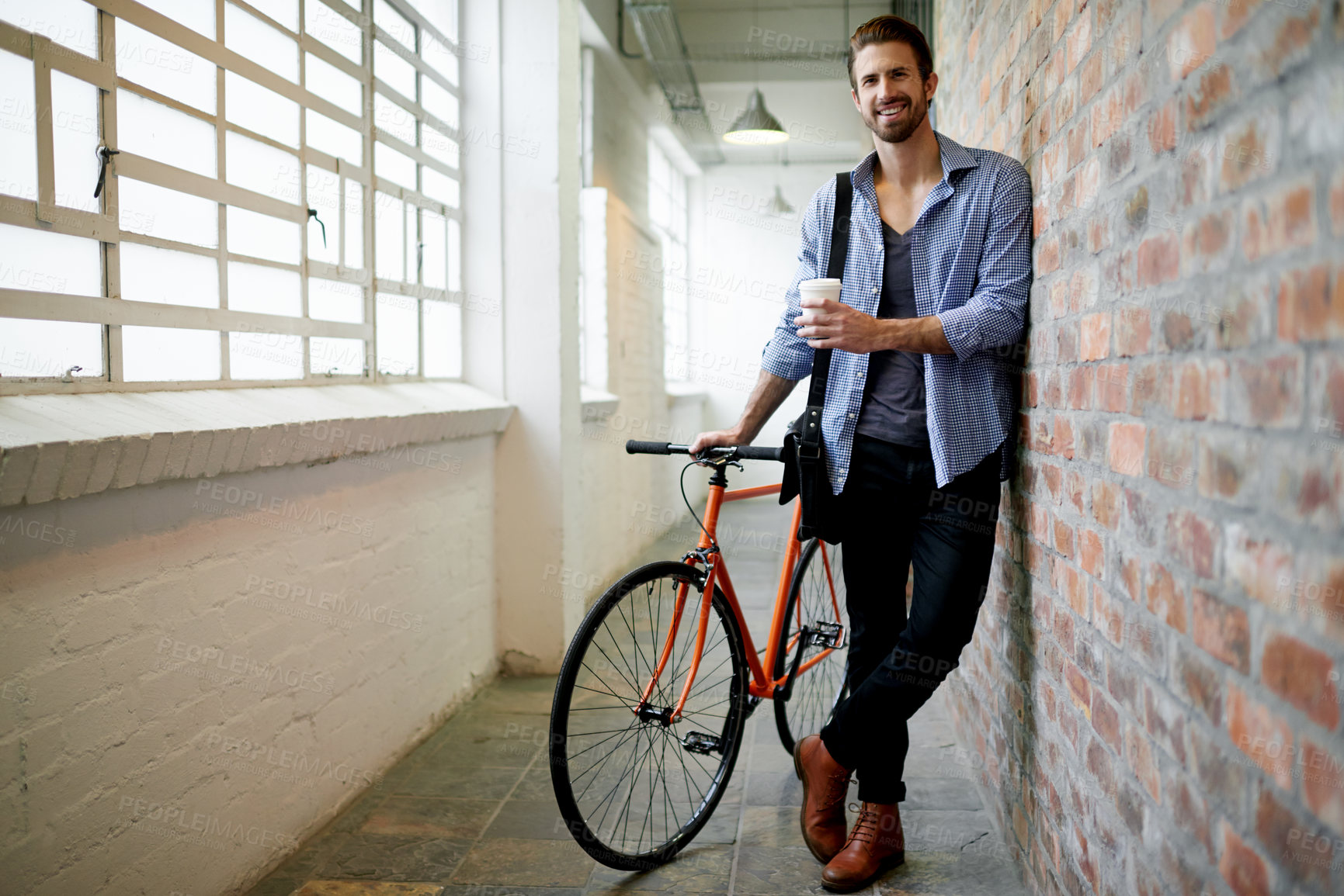 Buy stock photo Portrait, bicycle and man in hallway, smile and coffee with commute, morning and confidence. Face, happy person and guy with bike, carbon footprint or eco friendly travel with pride or sustainability