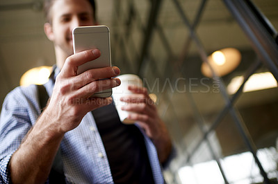 Buy stock photo Man, coffee and phone in hand for business, message and designer feedback in office. Low angle, creative person and mobile in agency for communication, online review and project management with tasks
