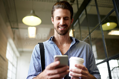 Buy stock photo Businessman, coffee and walking with phone in office for text message, checking notifications and work arrival. Professional, employee and happy with smartphone at workplace for social media or below