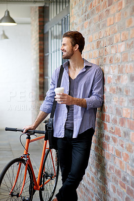 Buy stock photo Coffee, bicycle and man in city in morning for travel, journey or commuting to work with creative career. Happy, bike and male magazine writer with eco friendly transport by brick wall in urban town.