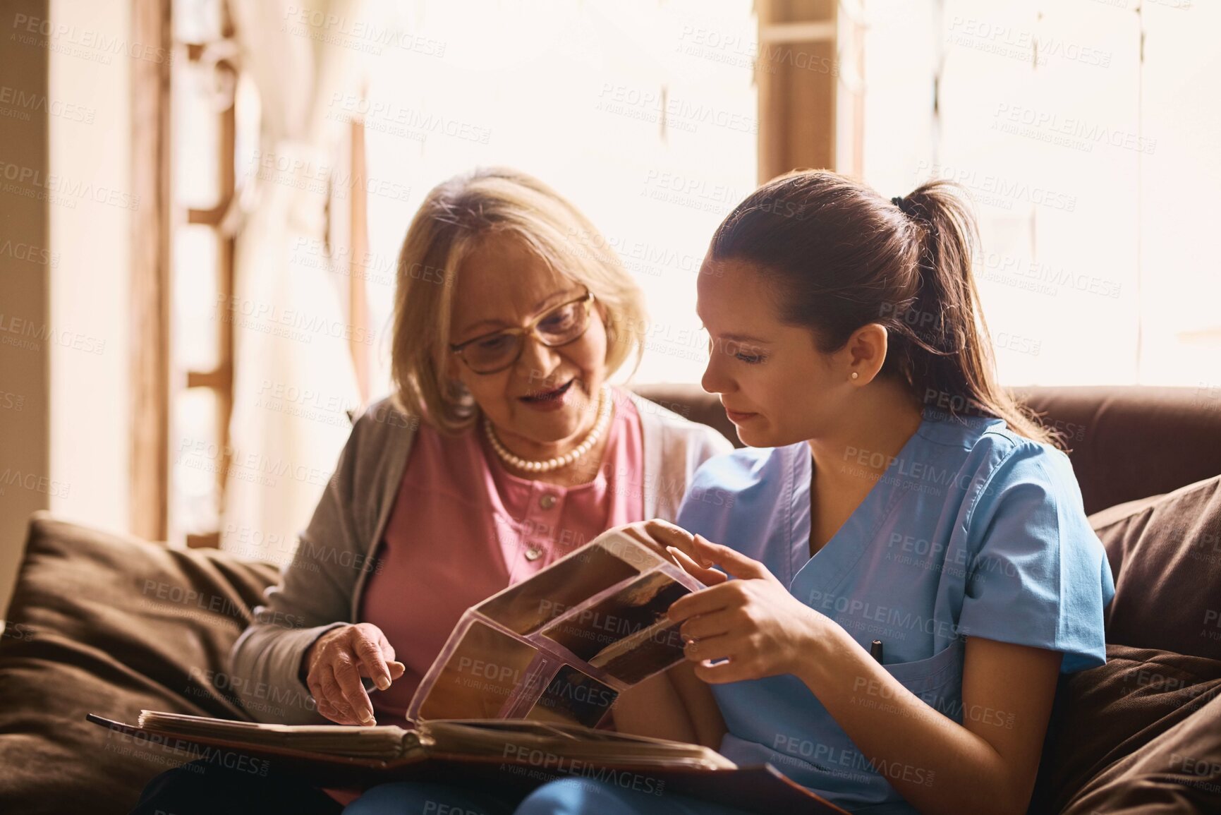 Buy stock photo Senior, woman and nurse with photo album on sofa for memories, nostalgia and remember with support. Elderly, person or female caregiver in assisted living with talking of pictures, empathy or bonding