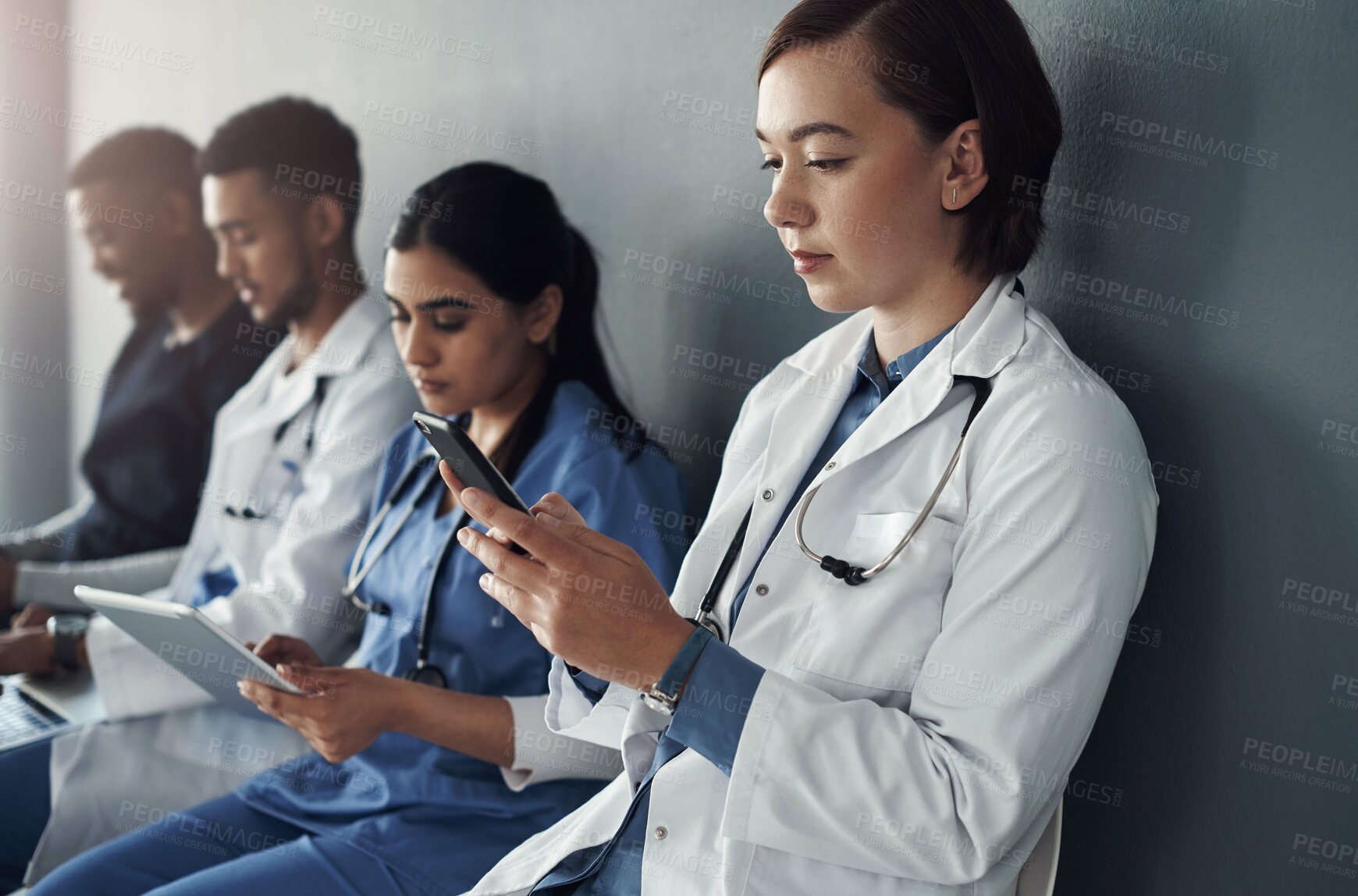 Buy stock photo Chairs, team and technology with doctors by wall for interview or public health conference and training meeting. People, medical staff and line for patient rounds or daily briefing, review and online