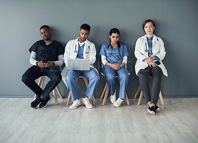 Buy stock photo Chairs, team and technology with doctors by wall for interview or public health conference and training meeting. People, medical staff and line for patient rounds or daily briefing, review and online