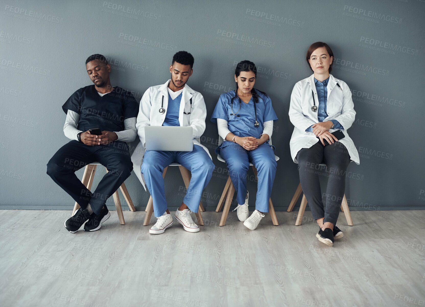 Buy stock photo Chairs, team and technology with doctors by wall for interview or public health conference and training meeting. People, medical staff and line for patient rounds or daily briefing, review and online