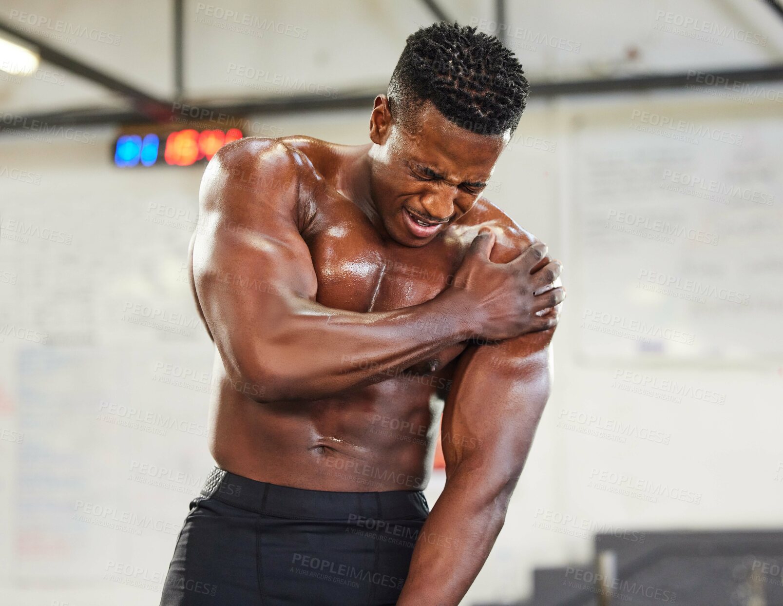 Buy stock photo African man, gym and shoulder injury in pain with fitness, muscular and exercise at workout. Bodybuilder, hurt and holding arm for torn muscle, burnout and strain in sports or weightlifting