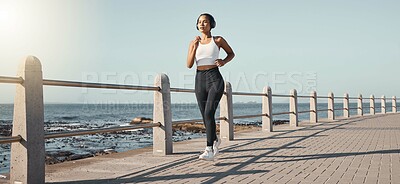 Buy stock photo Fitness, woman run at beach and with headphones listening to music for health wellness. Training or exercise, marathon or lens flare and female person running along the promenade listen to radio