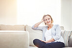 Happy mature woman relaxing on a sofa alone at home