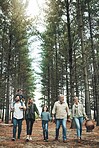 Forest, holding hands and big family walking in nature for outdoor hiking, adventure and wellness holiday with trees. Diversity, adoption and happy community in woods for earth day love celebration