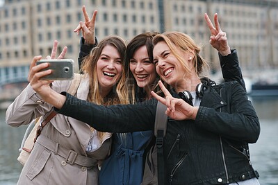 Buy stock photo Corporate women, selfie and peace in city with friends, profile picture and happy on travel. Young executive group, smartphone or solidarity for social media, blog and post by river in London metro