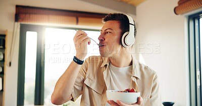 Buy stock photo Headphones, eating and man with breakfast in kitchen  listening to podcast in morning for self care. Audio tech, health and male person enjoying fruit salad for diet, nutrition or wellness in home.
