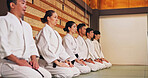 Discipline, kneeling and people in martial arts studio for practice, training or self defense class. Culture, karate and group of students with respect, honor or etiquette gesture to master in dojo.
