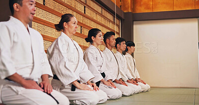 Buy stock photo Discipline, kneeling and people in martial arts studio for practice, training or self defense class. Culture, karate and group of students with respect, honor or etiquette gesture to master in dojo.