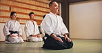 Kneeling, greeting and people in martial arts studio for practice, training or self defense class. Culture, karate and group of students with respect or etiquette gesture to master in dojo for honor.