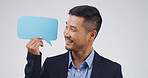 Speech bubble, mockup space and businessman in studio for announcement, opinion or voice. Happy, social media and Asian male person with text board, blank sign or placard vote by white background.