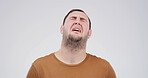 Sad, depression and man crying in studio for grief, stress or disaster on white background with space. Anxiety, unhappy and person with mental health crisis, bad news and mourning with loneliness