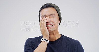Buy stock photo Asian man, crying and sad in studio with depression, grief or loss with emotion on white background. Space, tears and crisis with male person in mourning, distress with mental health and unhappy