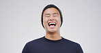 Funny, laugh and Asian man in studio for comedy, goofy joke or good mood on white background. Excited, smile and male person with happiness, comic news and crazy expression for humor with space