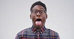 Silly, black man and portrait with funny face or tongue out for joke on a white studio background. Male person, model or humor with glasses, comic or quirky personality for comedy on mockup space