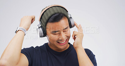 Buy stock photo Man, music and dancing with headphones in studio for hip hop playlist, streaming audio and rhythm. Mockup, person and energy on white background for listening to sound track, good vibes and movement