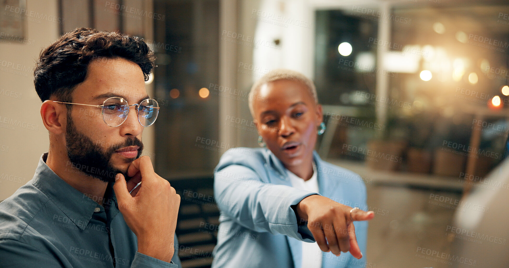 Buy stock photo Collaboration, computer and pointing with business people in office for problem solving or planning at night. Conversation, feedback or review with man and woman at work late for project management