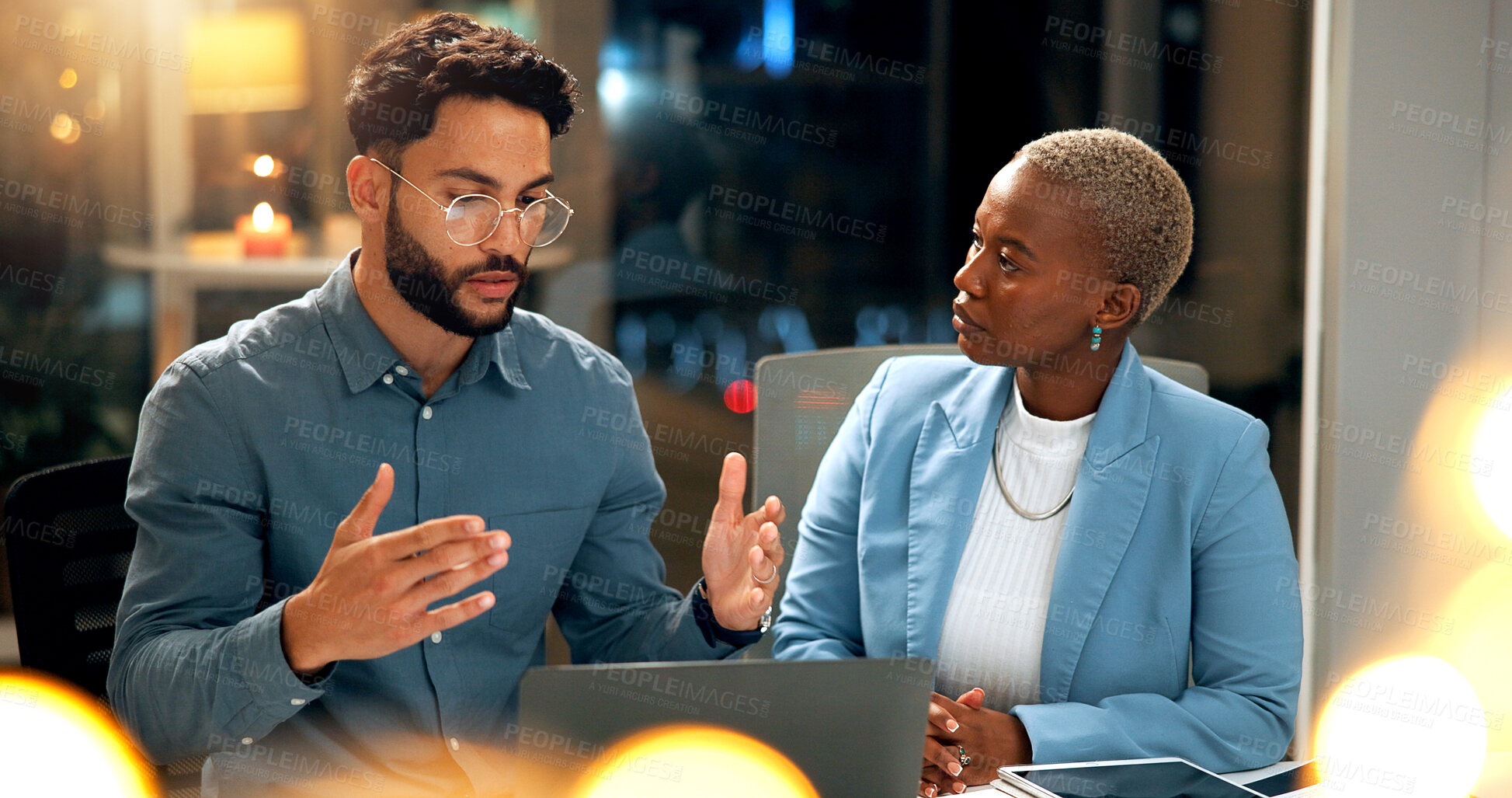 Buy stock photo People, meeting and explain with laptop at night for planning, story ideas and project deadline. Man, feedback and brainstorming with team, research and article schedule for publication for overtime