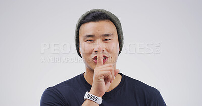Buy stock photo Happy, portrait and man in studio with secret, gossip or confidential hand gesture for privacy. Quiet, smile and Asian male person with finger on lips for silence or noise control by white background