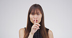 Portrait, student and woman with secret, confidential and gesture for privacy, mysterious or studio. White background, shush and person with sign for silence, pupil and finger for shut up or reaction