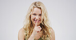 Portrait, student and woman with gesture for secret, studio and sneaky with mystery or confidential. Happy, pupil and person with sign for privacy, shush and finger for silence and white background