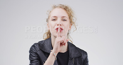 Buy stock photo Portrait, finger on lips and woman with whisper, shush and privacy sign on white studio background. Face, gesture and person with mystery news, silence and emoji with gossip, confidential and secret