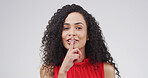 Portrait, secret and woman with finger on lips in studio for mute, quiet or privacy gesture for gossip. Smile, confidential and person from Mexico with silent sign for rumor by white background.