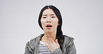Asian woman, sore throat and pain with hand on neck for breathing, tonsillitis or enlarged adenoids. Sick person, studio and infection symptom of flu, thyroid or pharyngitis on white background